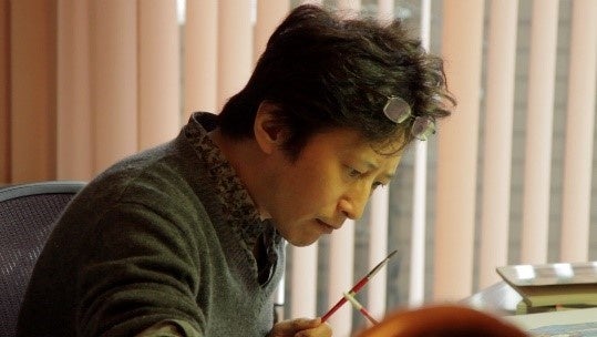 記事画像3: 筆を持つ男性の横顔