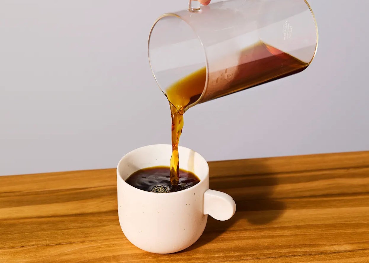記事画像10: コーヒーがガラス製カラフェから白いカップに注がれている。