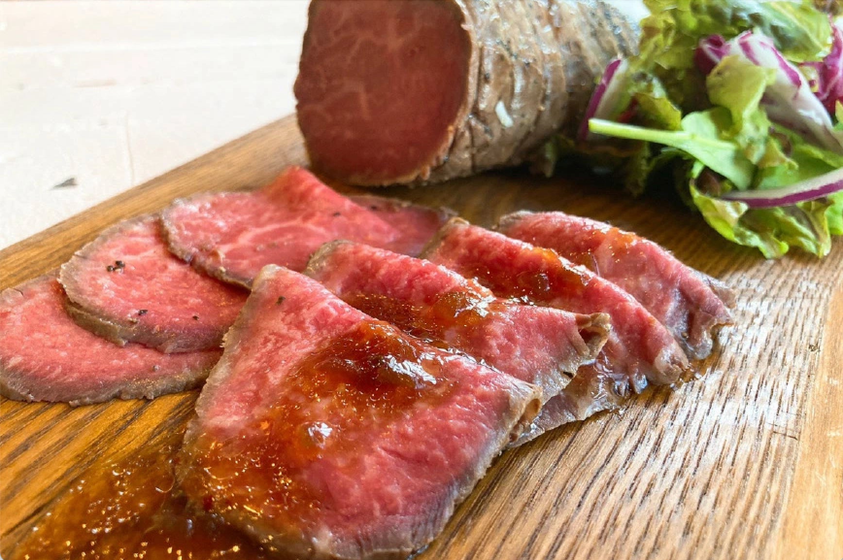 記事画像2: ローストビーフとサラダが木製プレートに盛られている。