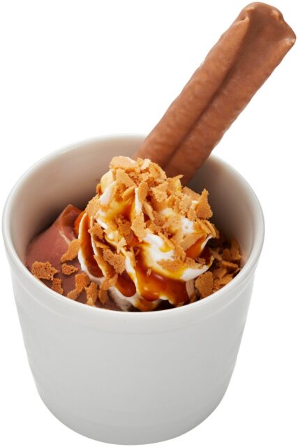 記事画像2: 濃厚なチョコレートアイスクリームにホイップクリームとキャラメルソース、クランチーなトッピングを乗せ、チョコレートスティックを添えたデザート。