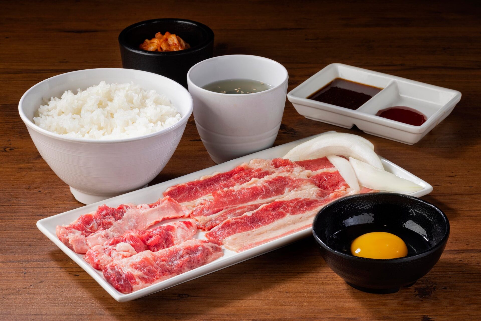 記事画像2: 焼肉セット:生卵、ご飯、キムチ、タレ、牛肉、玉ねぎ。