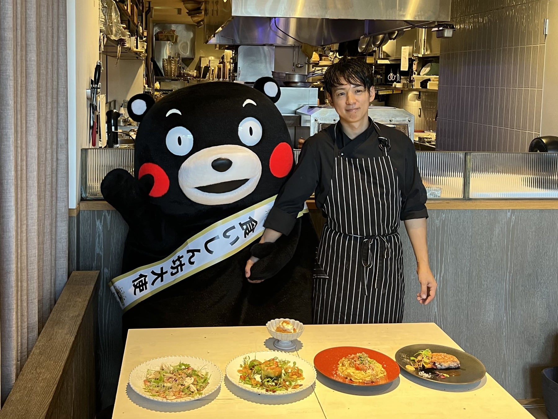 記事画像6: くまモンとシェフが料理を並べてポーズをとっている