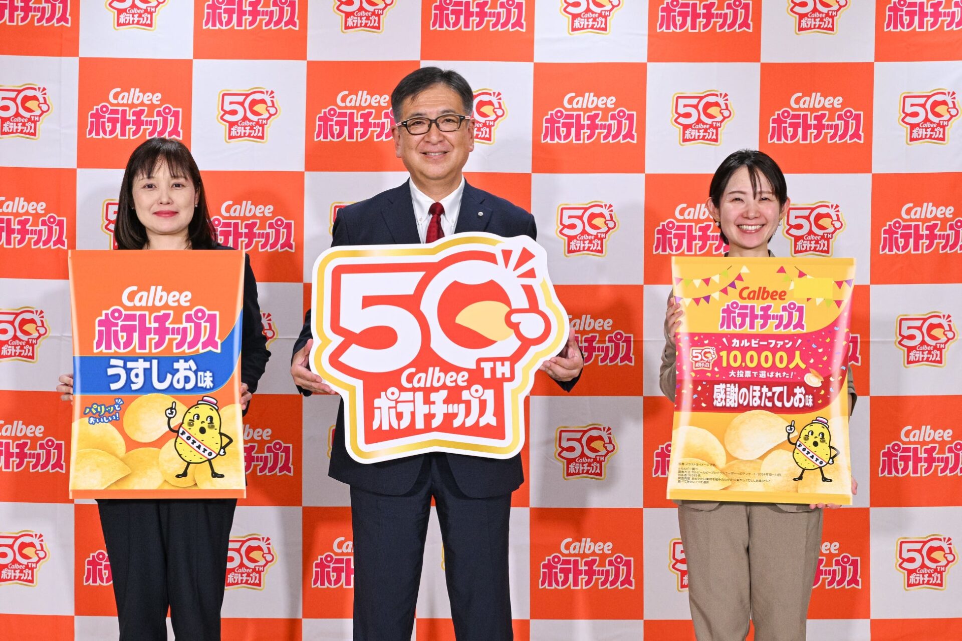 記事画像1: カルビーポテトチップス50周年記念イベントで、関係者が商品やロゴを持ってポーズ