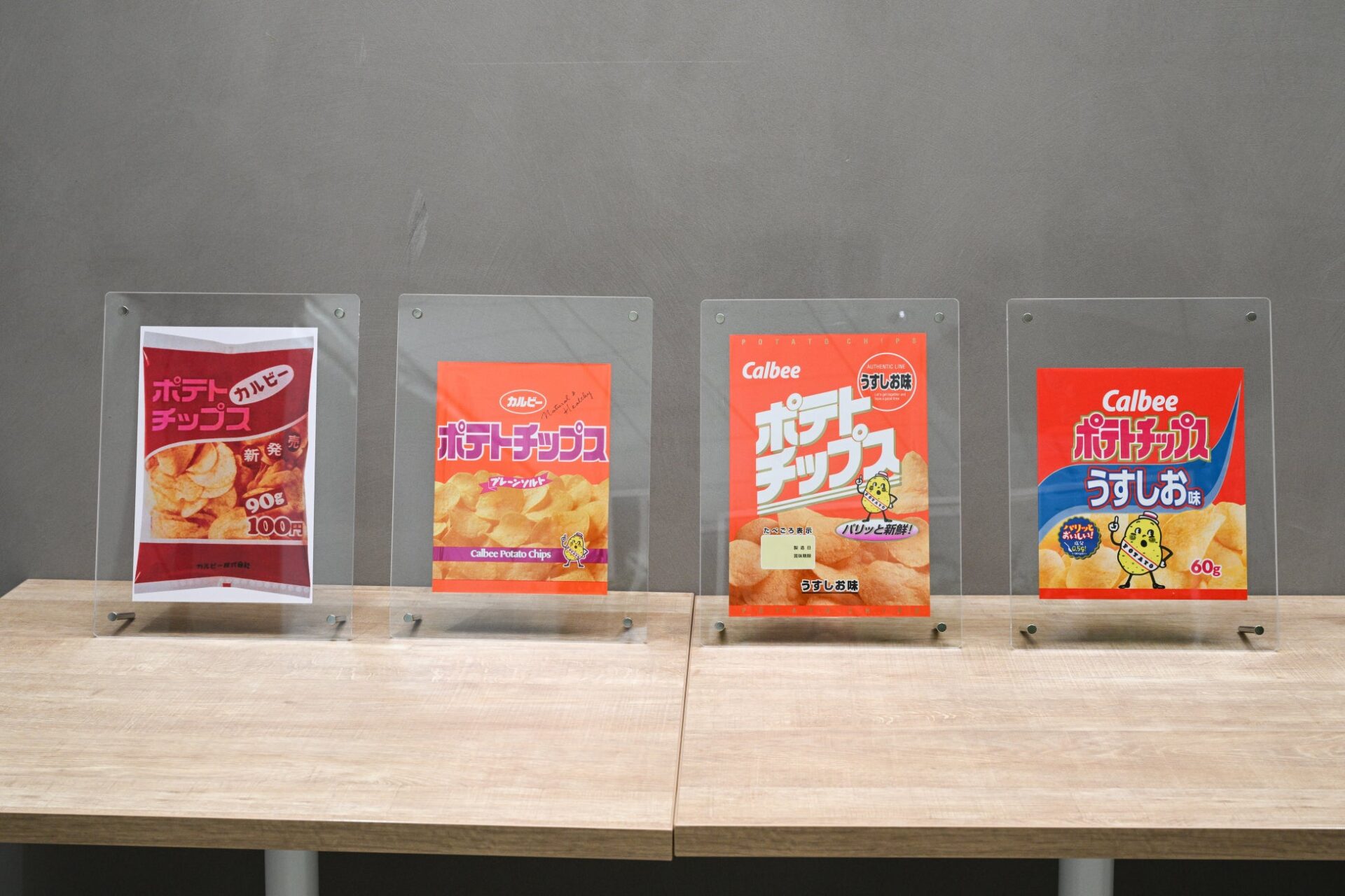 記事画像5: カルビーのポテトチップス「うすしお味」のパッケージが4種類並べて展示されている。
