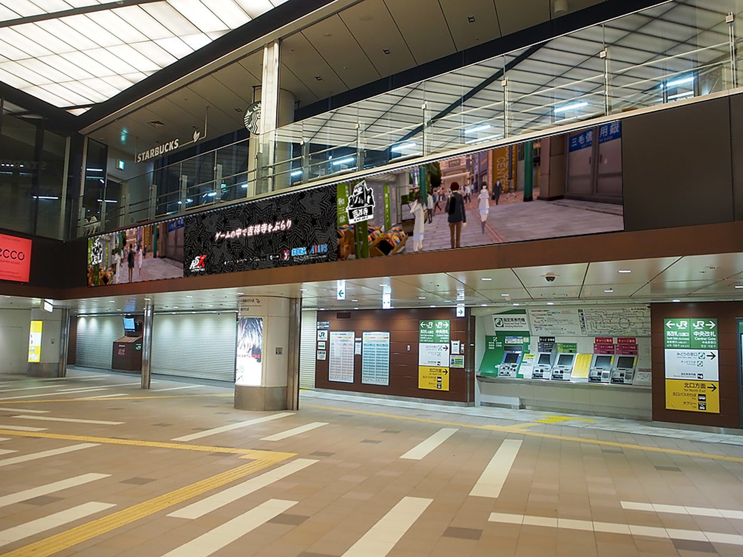 記事画像1: 駅構内の大型モニターにゲーム「ペルソナ」の広告が映し出されている。