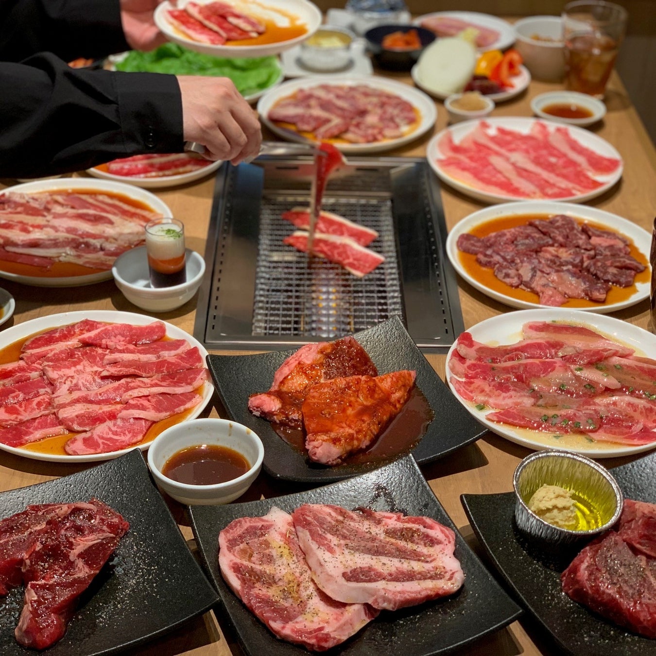 記事画像3: テーブルに並べられた焼肉用のお肉と、網で焼かれている様子
