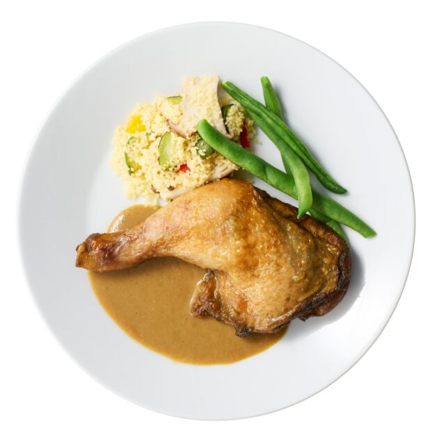 記事画像2: 丸い白い皿に盛られた、グリルチキン、クスクス、インゲン豆の料理