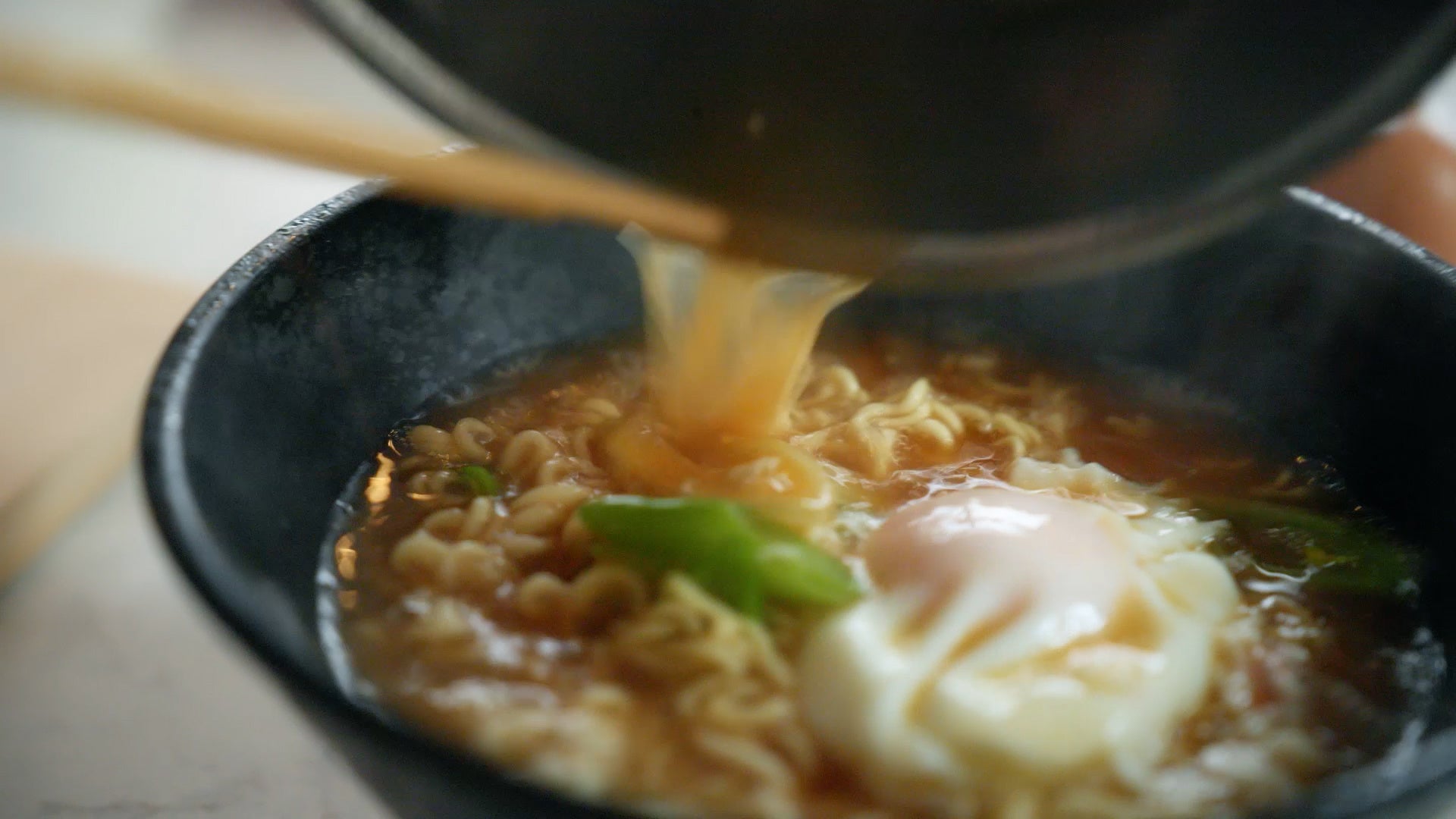 記事画像4: 熱々のラーメンに温泉卵とネギが載せられた美味しそうな一杯