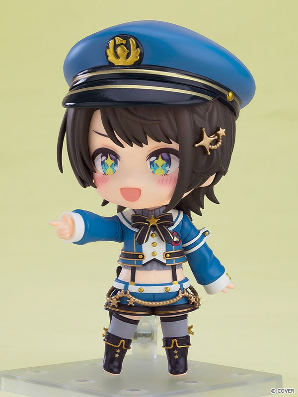 青い制服を着たアニメ風フィギュア、指を差している。