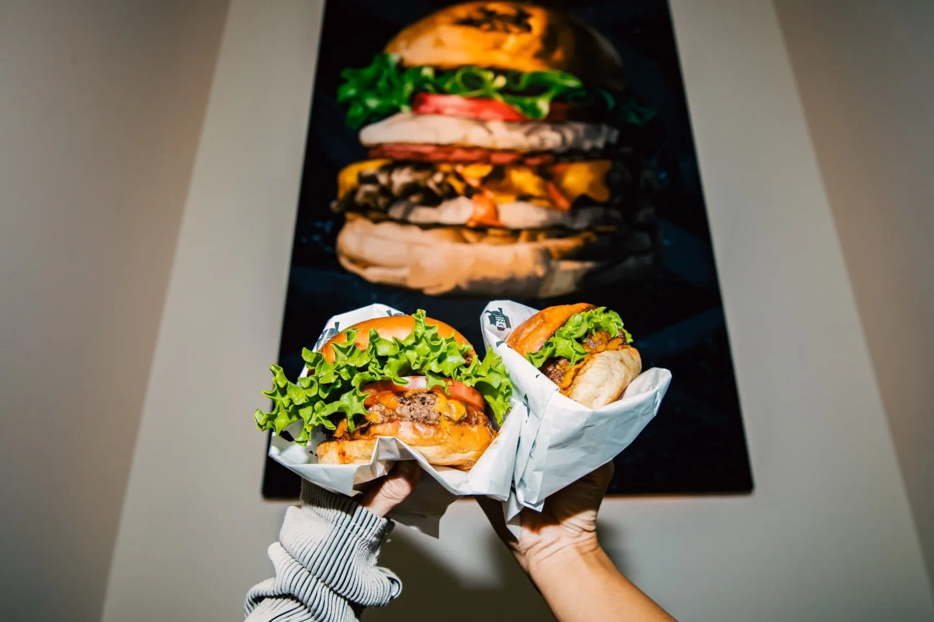 SHOGUN BURGERの月見バーガーを手に持った様子と店舗風景