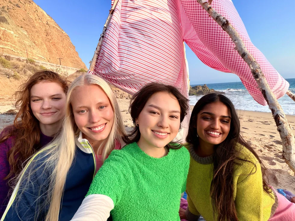 ビーチで楽しむ4人の女性のグループ写真