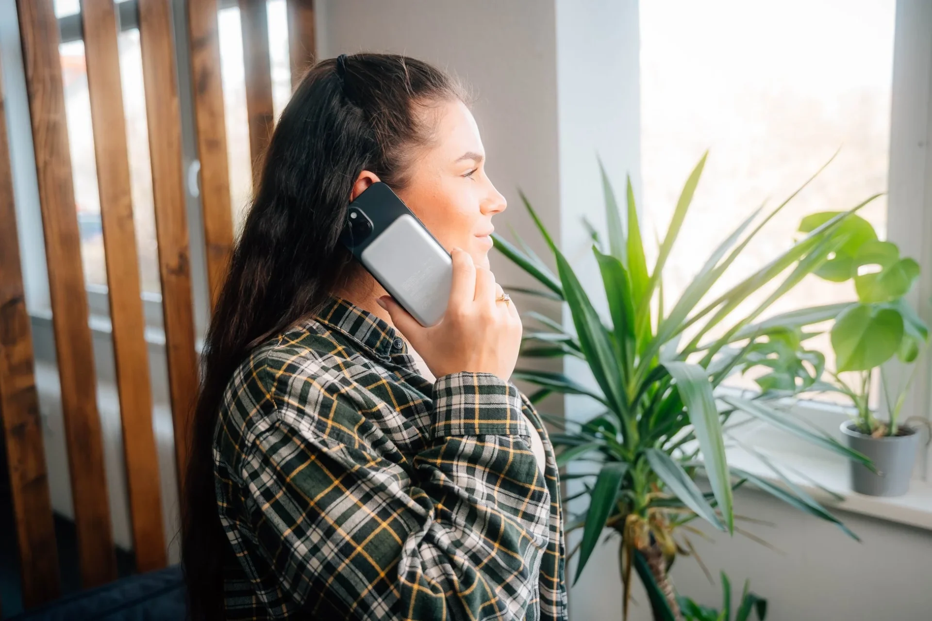 Verbatim MagSafeモバイルバッテリーを付けたスマホで通話する女性