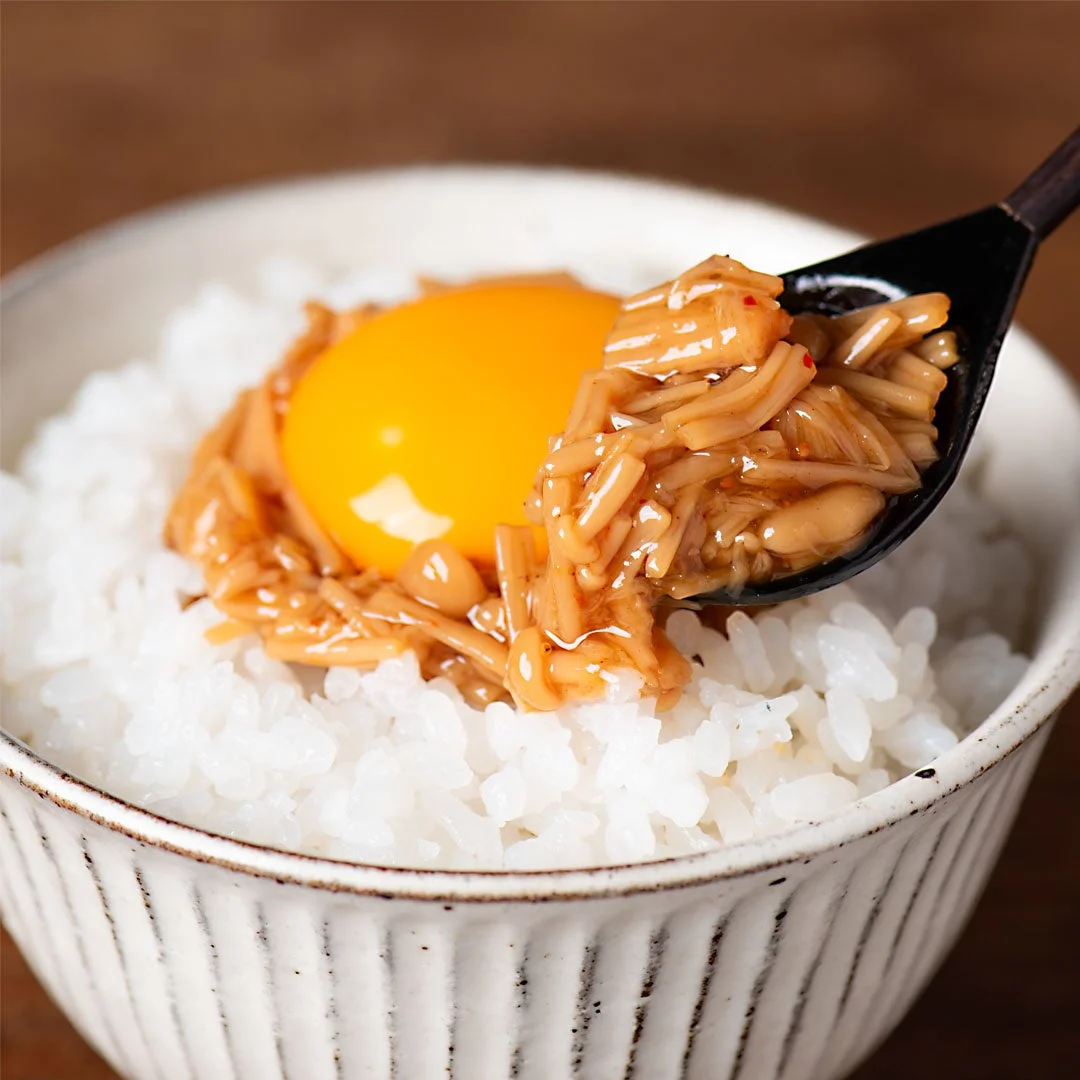 七味なめ茸と卵黄が乗ったご飯をスプーンですくう様子