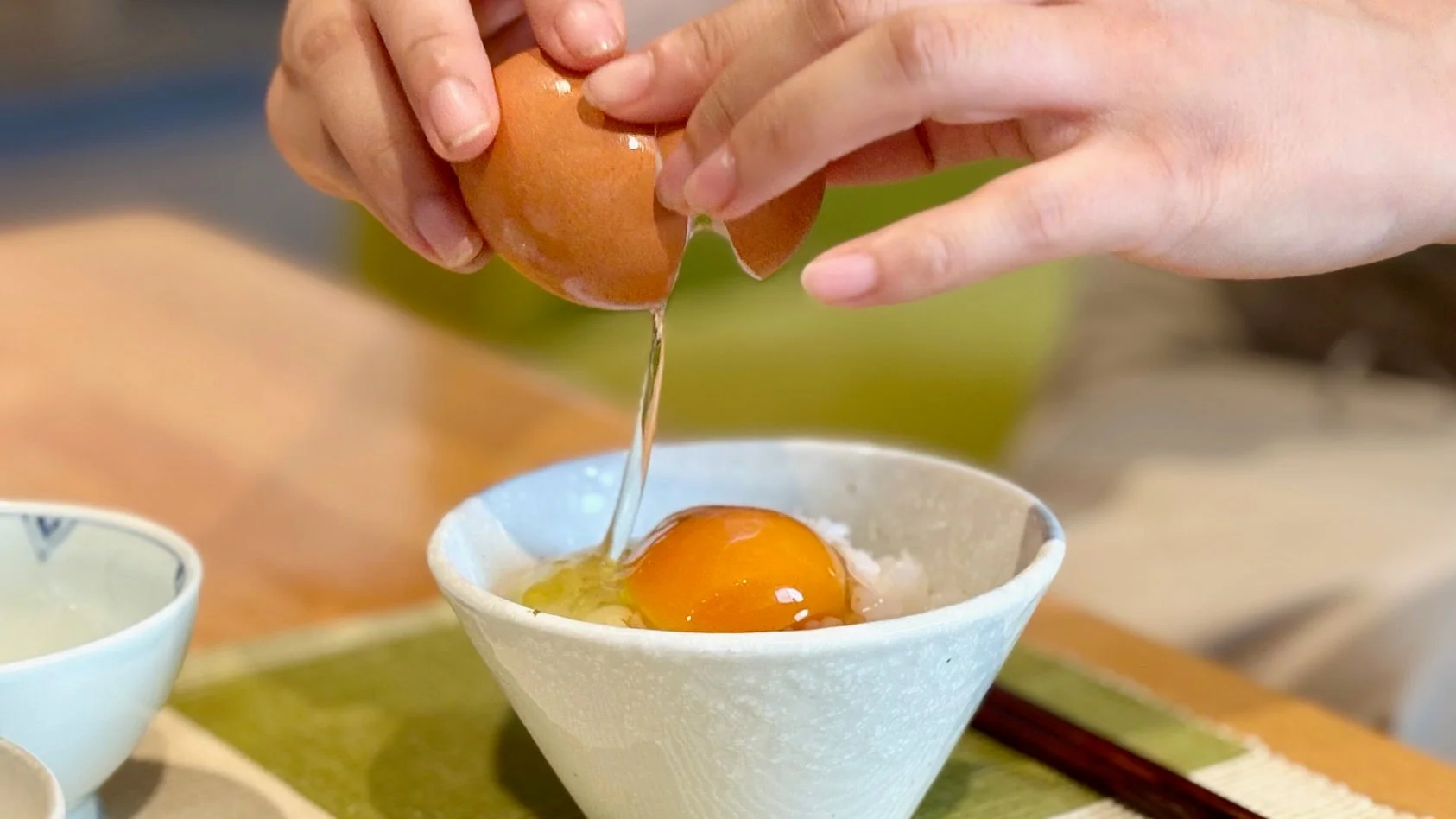 久世福商店スタッフが卵を割ってご飯にかける様子