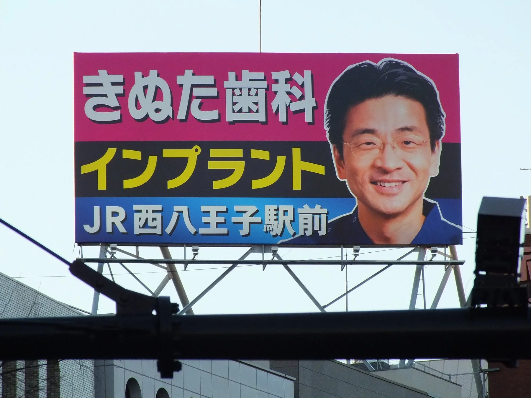 実際のきぬた歯科の大型看板広告「インプラント JR西八王子駅前」