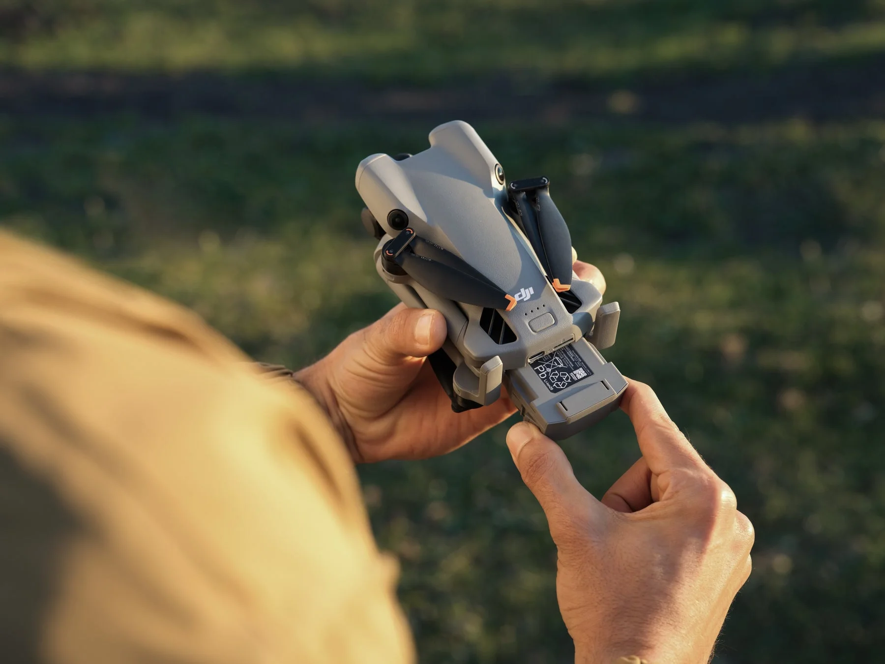 DJI Mini 5 Proドローンにバッテリーを装着する手