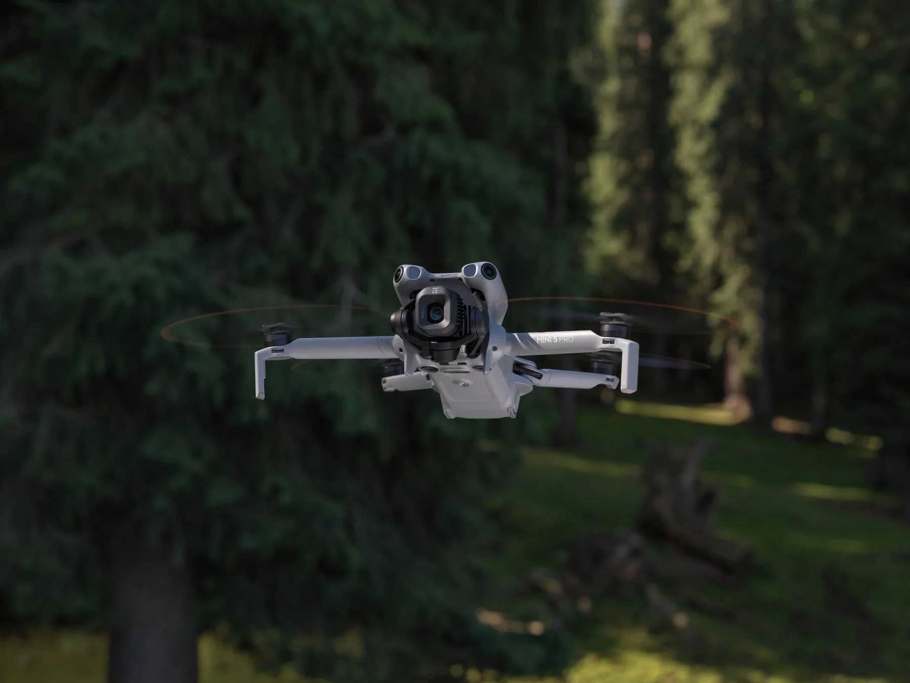 DJI Mini 5 Proドローンが緑豊かな森の上空を飛行する様子
