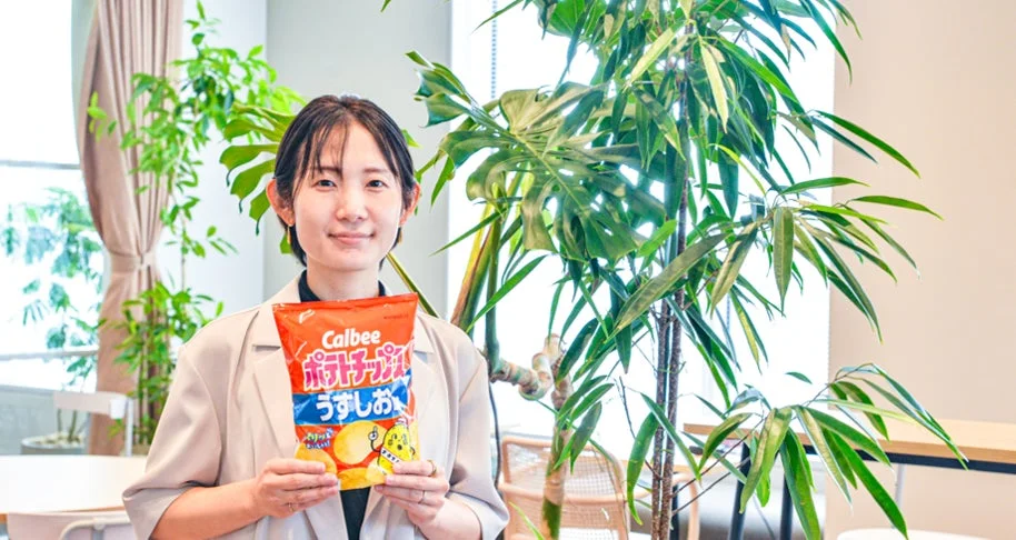 ポテトチップスうすしお味を持つ女性