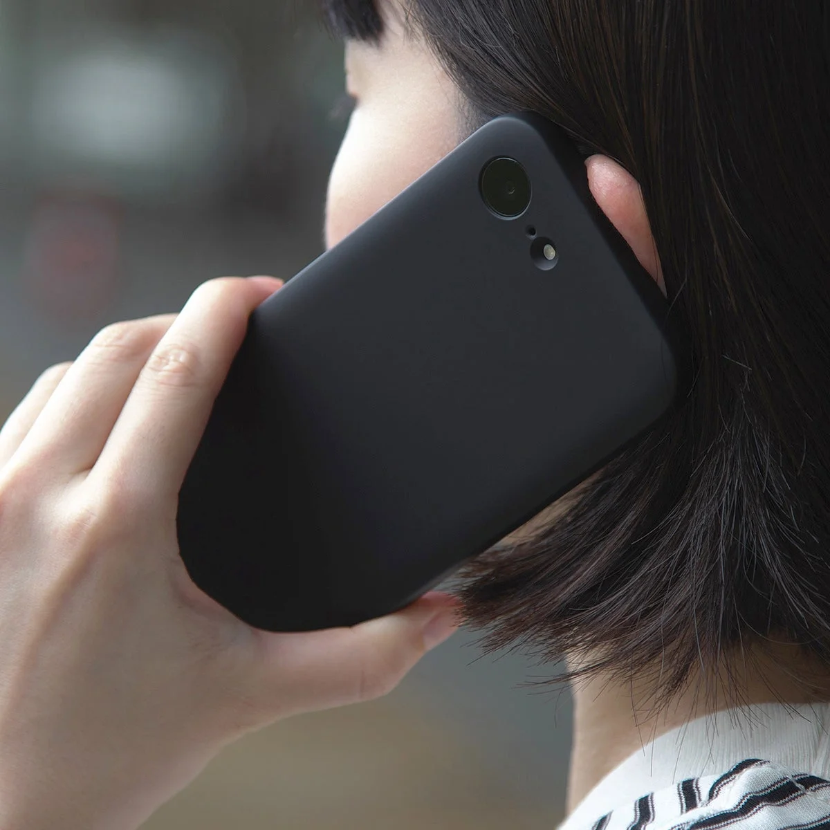 MYNUS iPhone 16e MAGCASE ラバーブラックで通話する女性