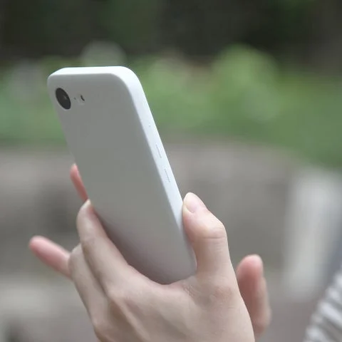MYNUS iPhone 16e MAGCASE サンドホワイトを持つ手元