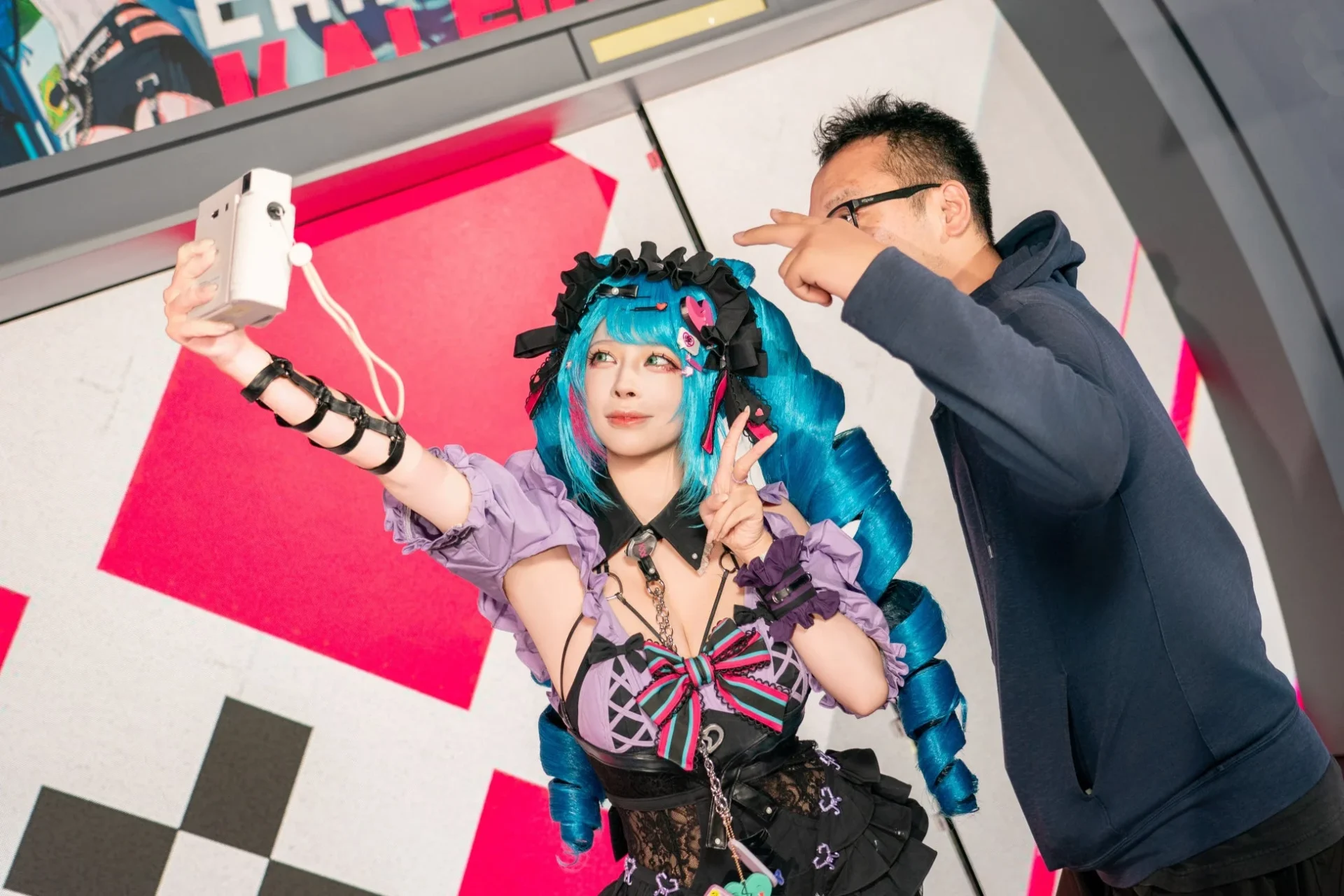 カレイドガチャイベントで来場者とチェキを撮るコスプレイヤー