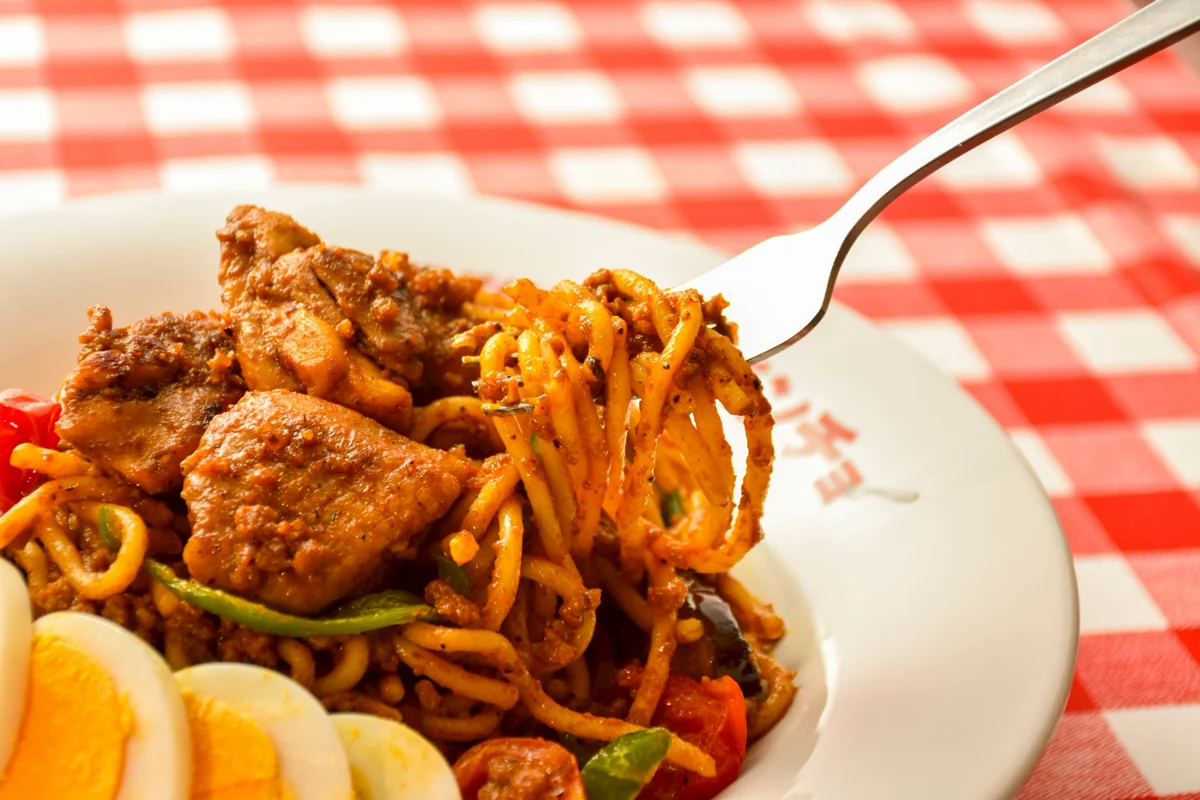 フォークで持ち上げられた「ゴロっとチキンのカレーナポ」の麺と具材