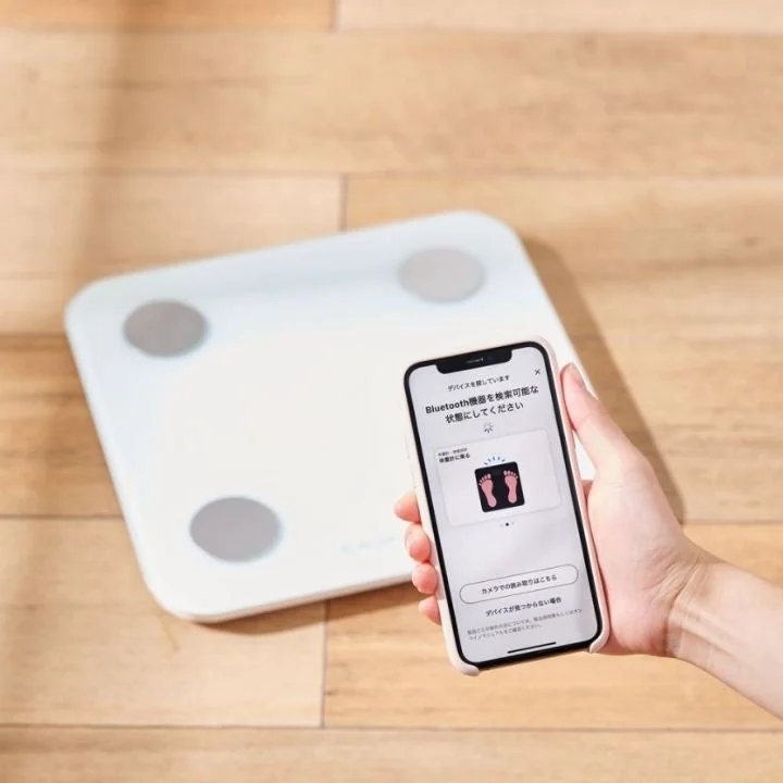 白い体組成計とスマートフォンでのBluetooth初期設定画面