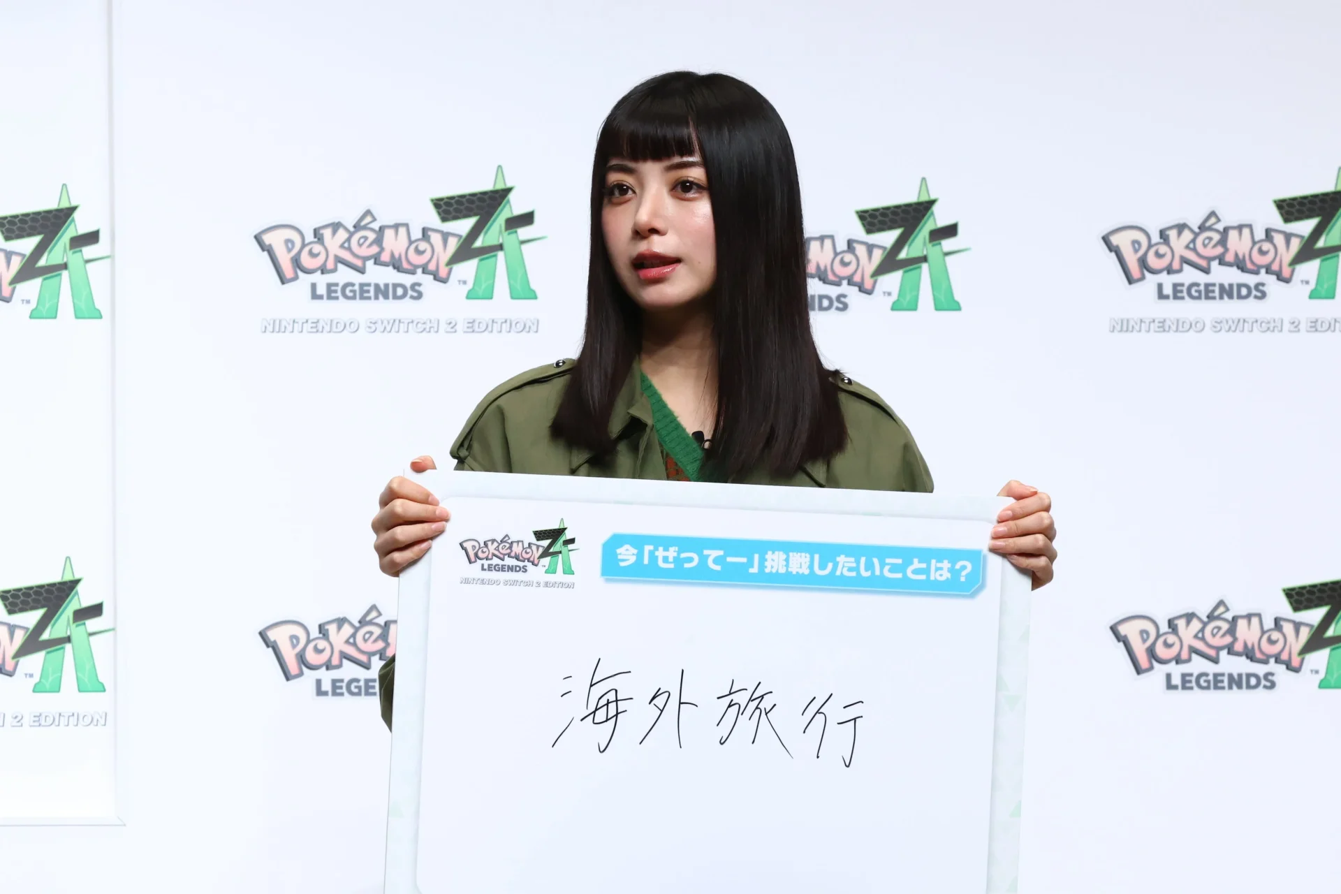 「海外旅行」とフリップを掲げる池田エライザさん