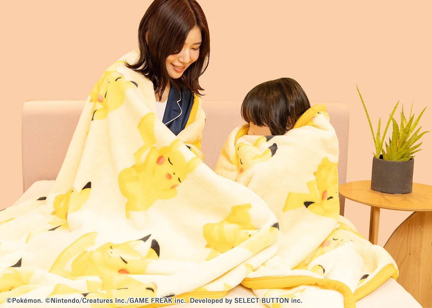 ピカチュウ柄のニューマイヤーブランケットを使用する親子