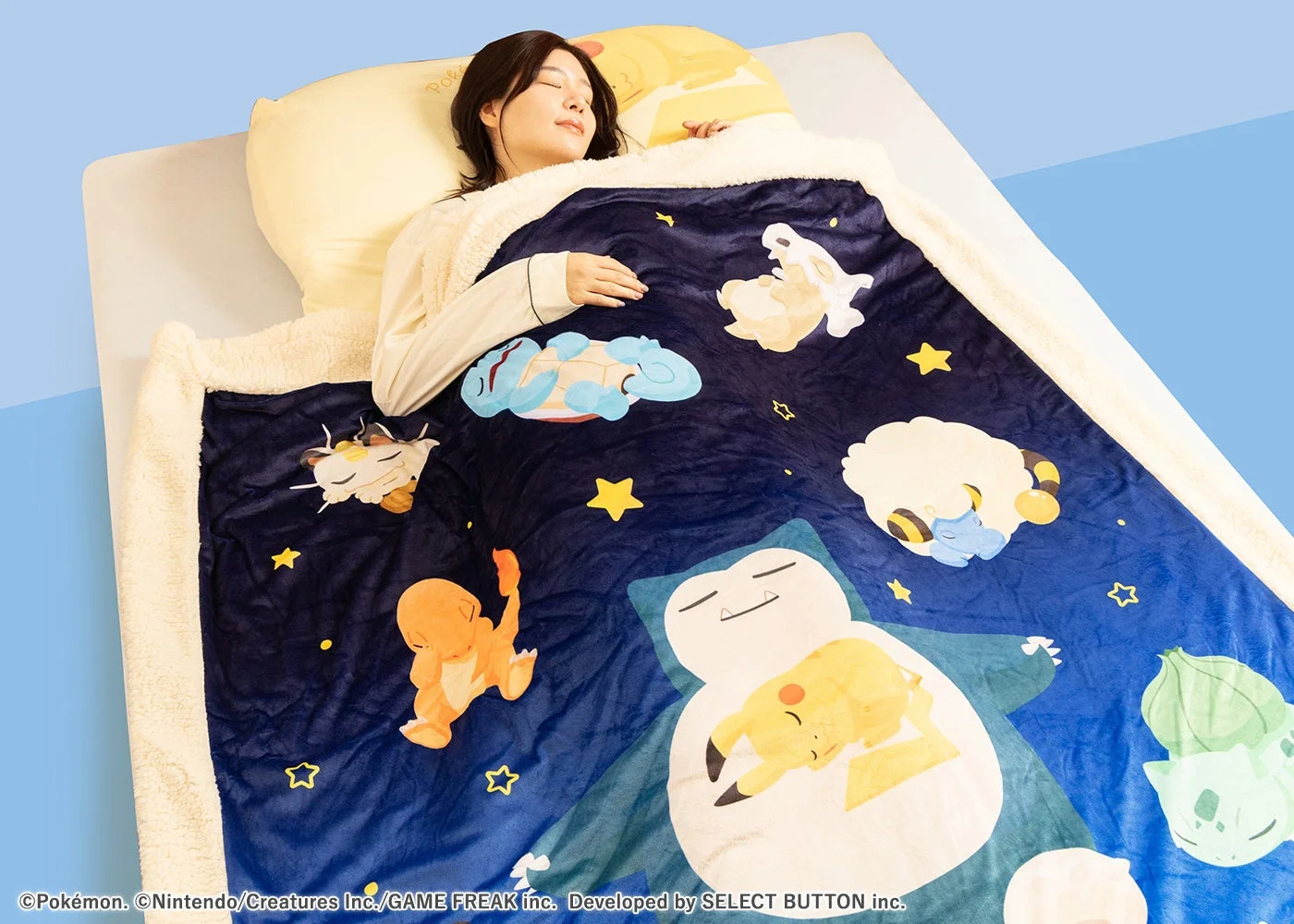 ポケモンたちがデザインされたわた入りボアブランケットで眠る女性