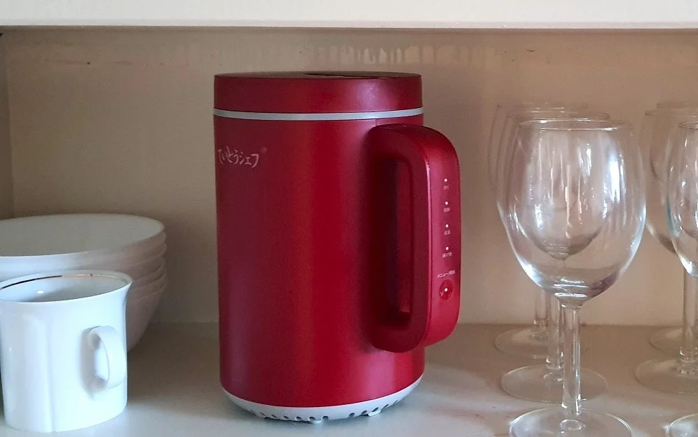 棚に置かれた赤いミニ炊飯器とグラス