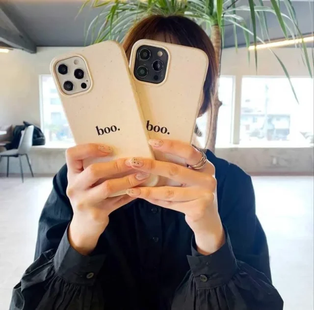 「boo.」とデザインされたオリジナルiPhoneケースを持つ手元