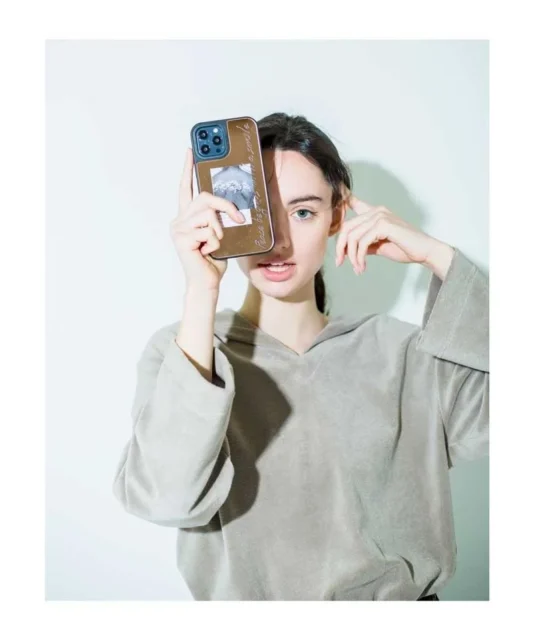 オリジナルデザインのスマホケースを持つ女性のポートレート