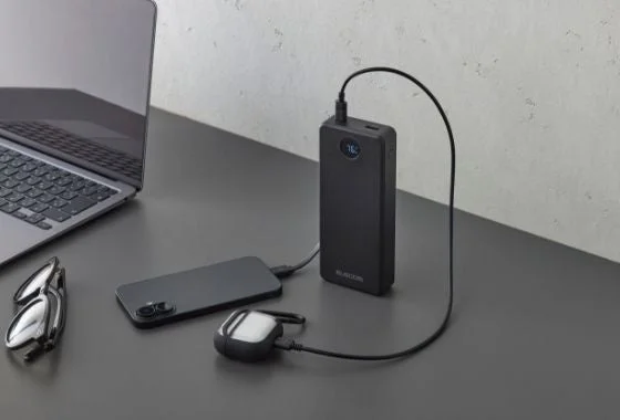 エレコムの黒いモバイルバッテリーでノートPCとスマートフォン、イヤホンを充電する様子