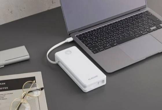 エレコムの白いモバイルバッテリーでノートパソコンを充電する様子