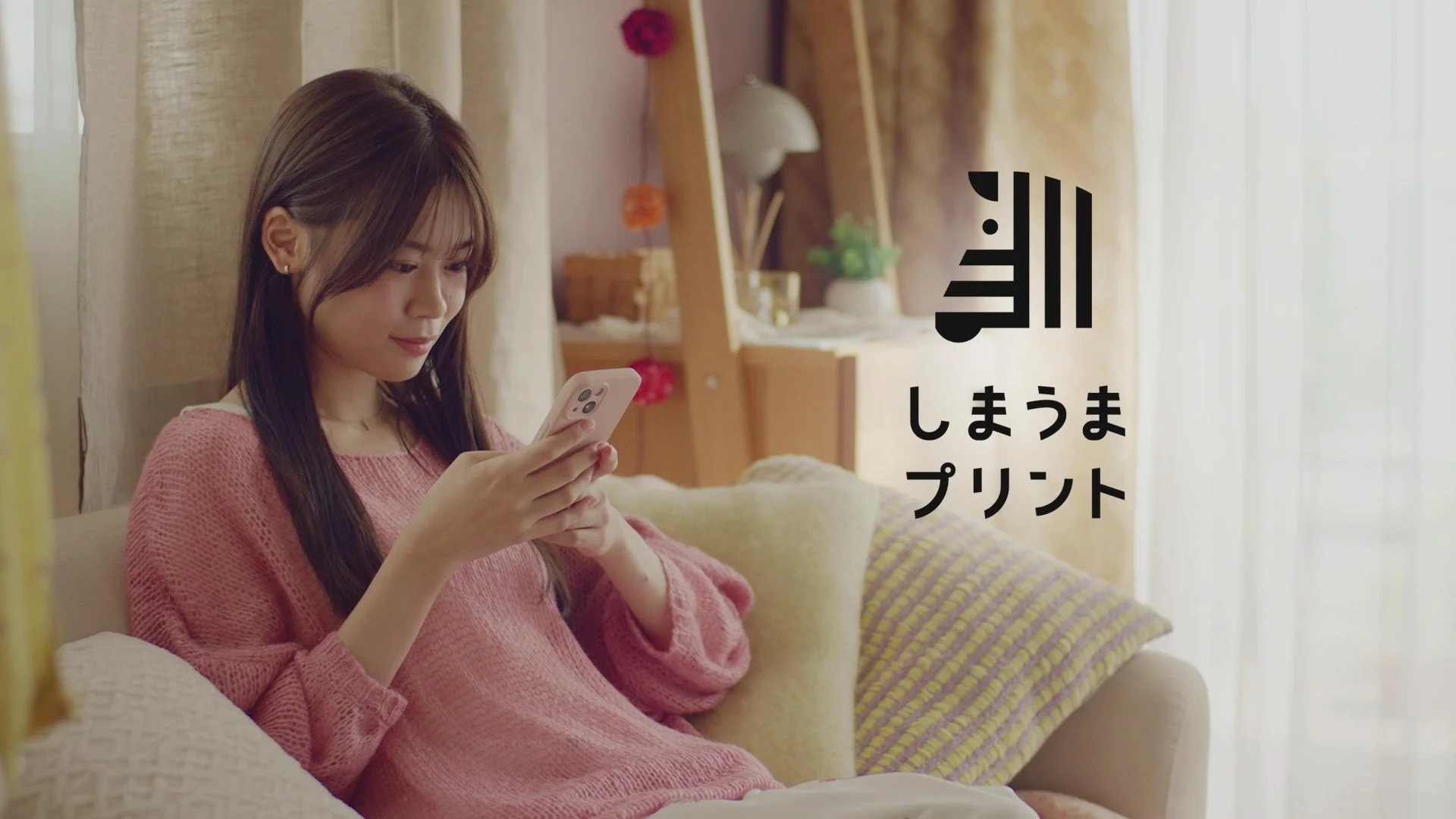 しまうまプリントCM「若年層編」スマホを見る若い女性とロゴ