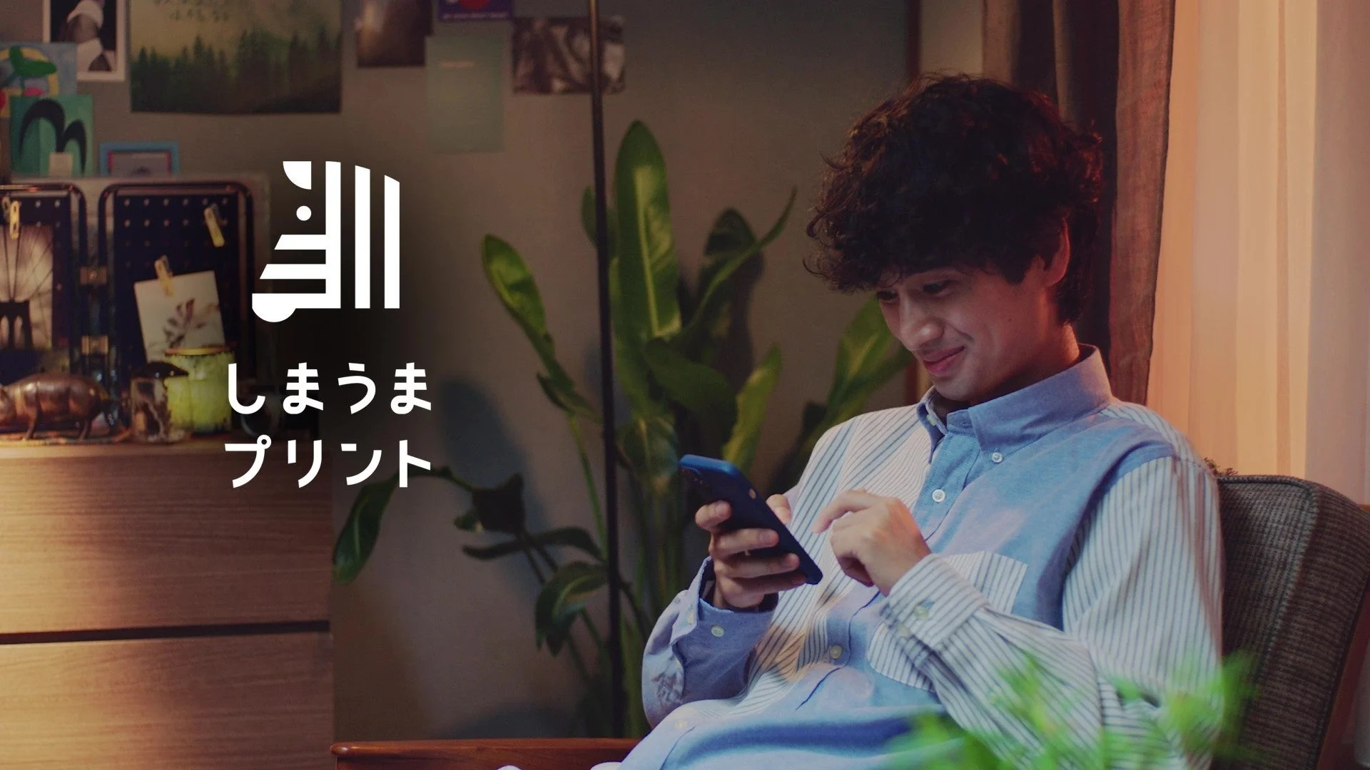 しまうまプリントCM「クリエイター編」スマホを見る男性とロゴ