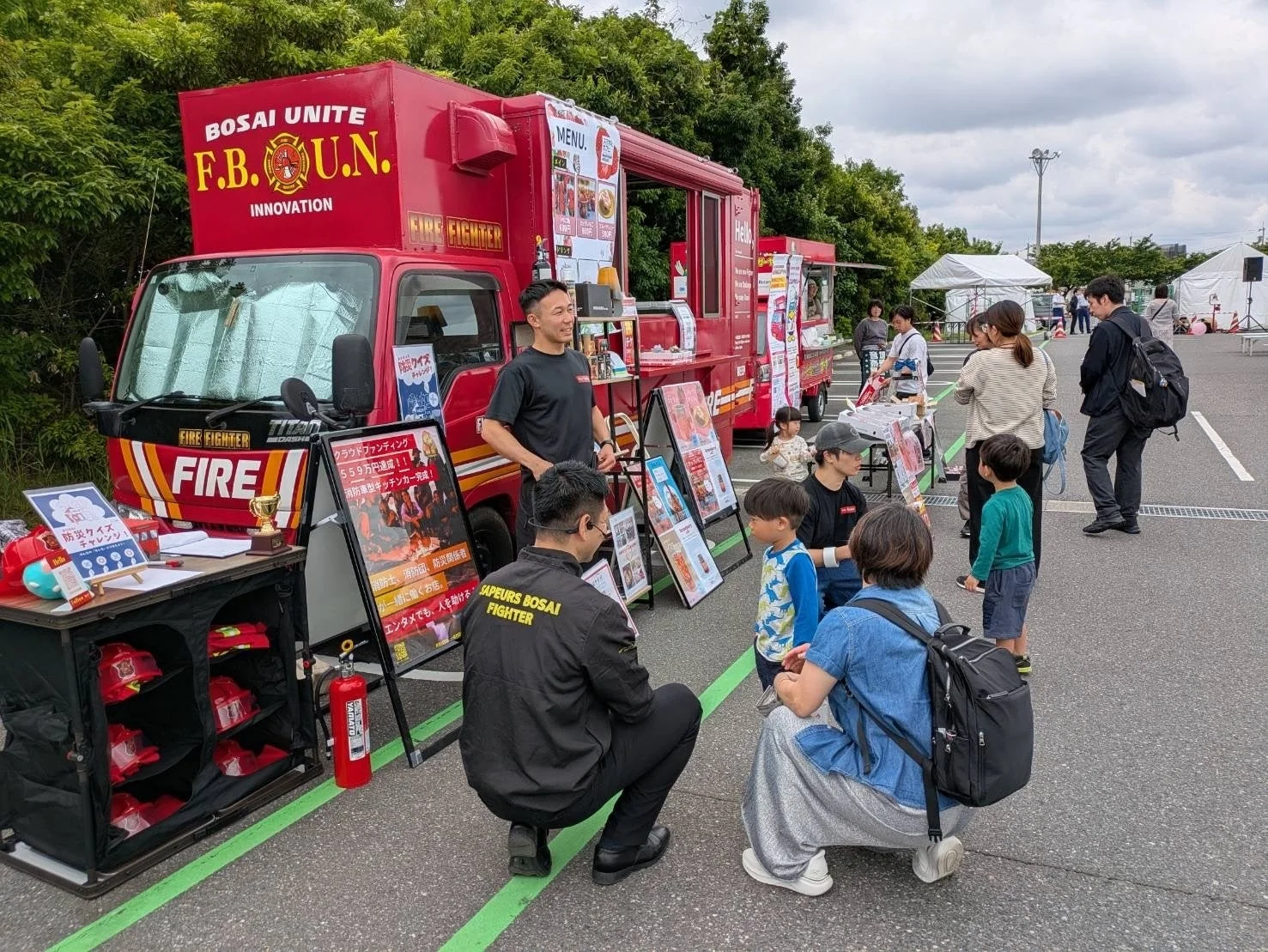 イベントで活動する消防車型防災キッチンカーと利用者の様子