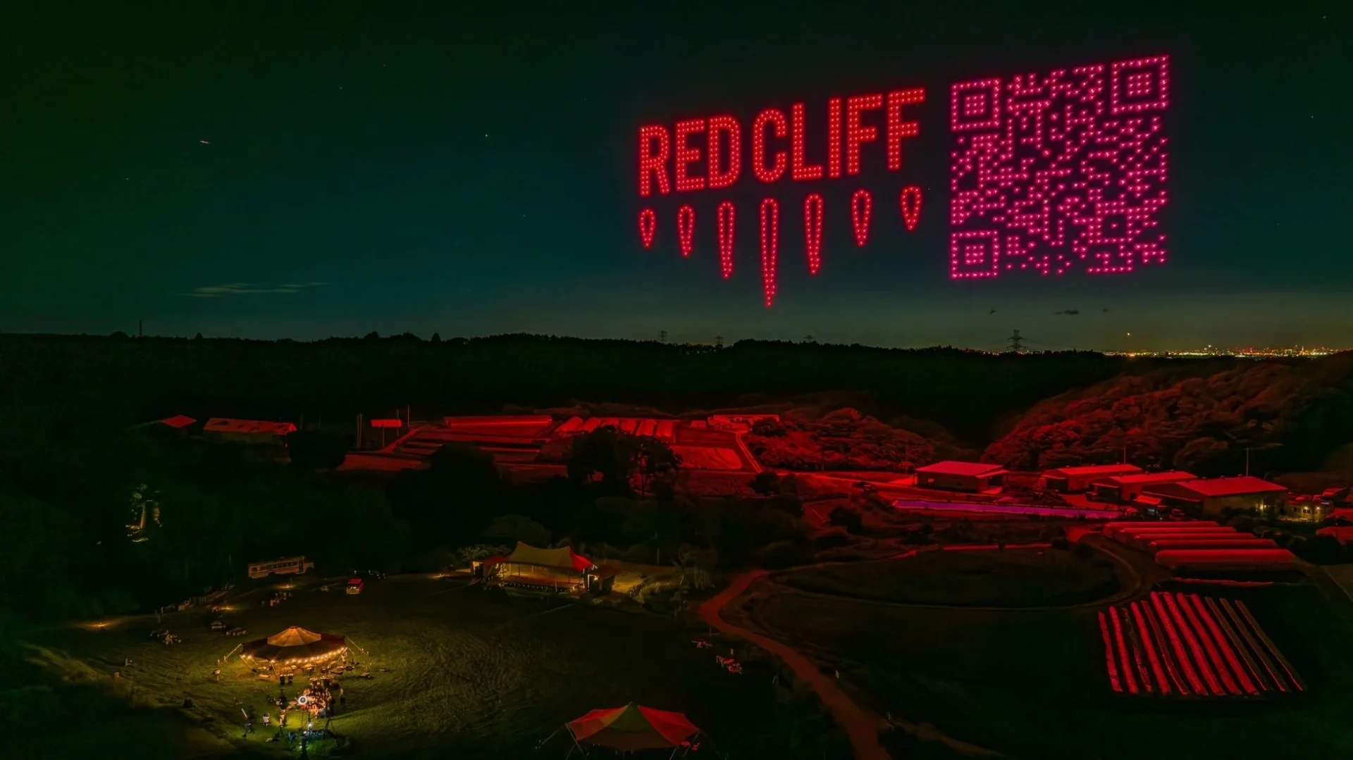 夜空にREDCLIFFの文字とQRコードが浮かぶドローンショーの様子