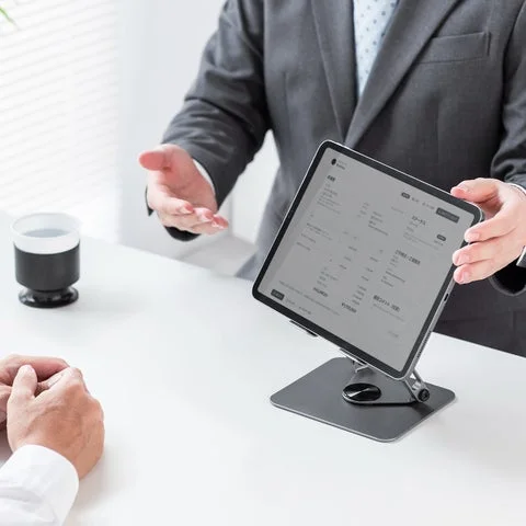 商談中にタブレット画面を相手に見せる様子