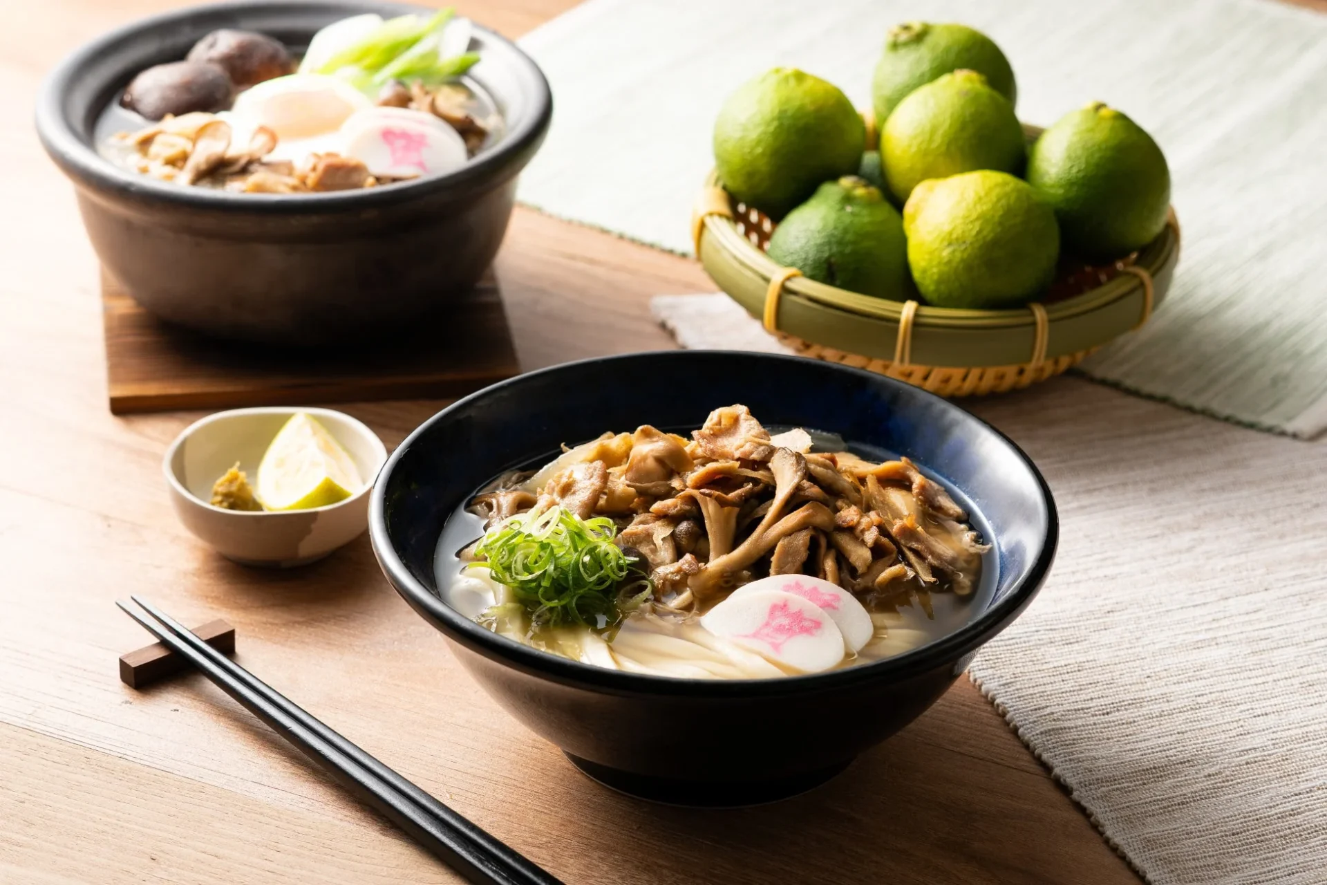 きのこかしわ汁うどんと鍋うどん、大分かぼすが並べられた食卓の様子