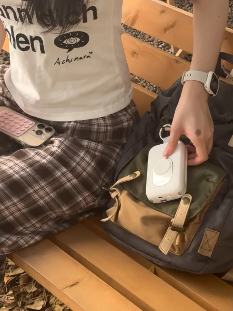 RORRY充電器をバッグから取り出す女性の手元