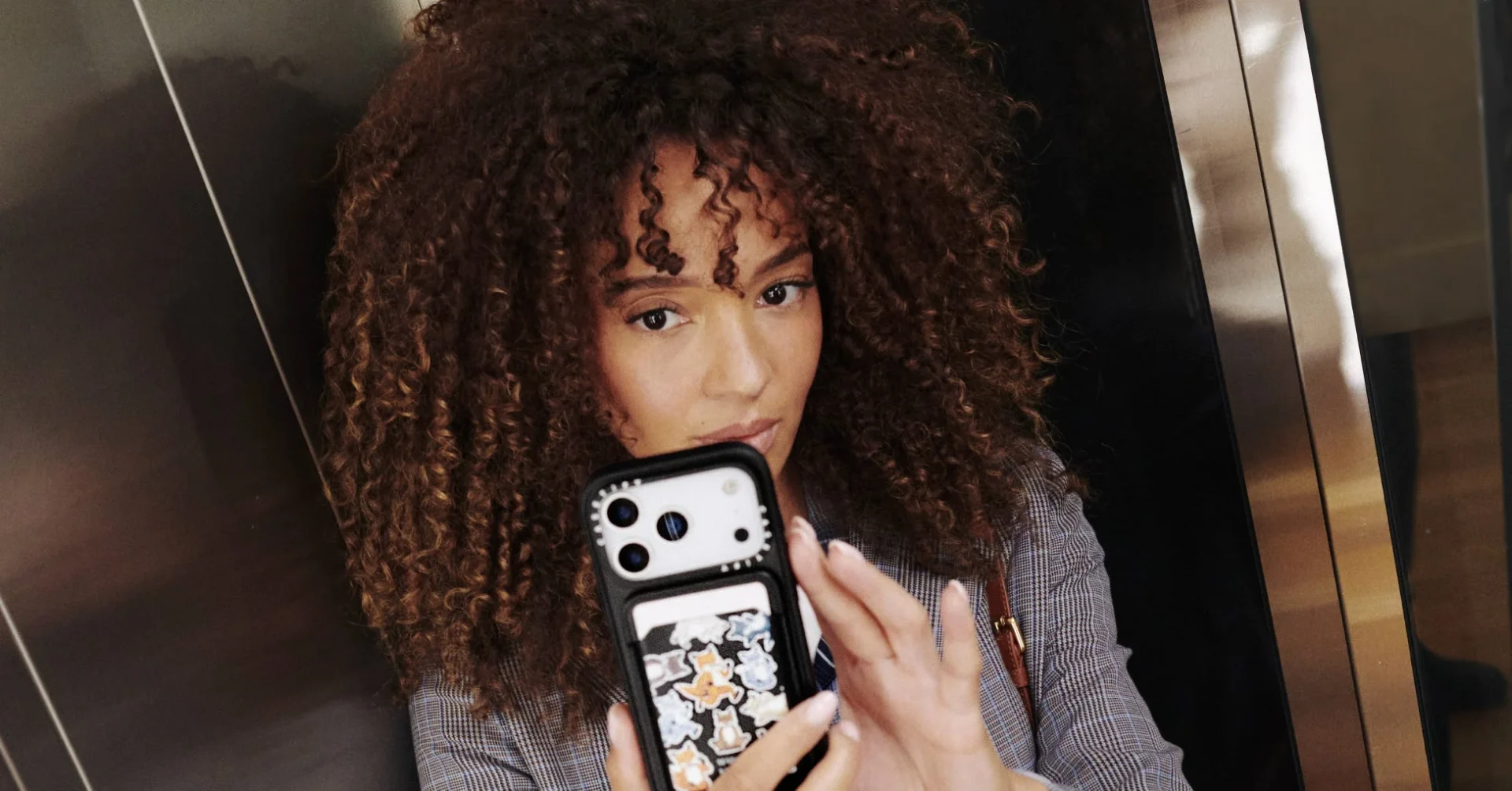 Maison Kitsuné x CASETiFYコラボのMagSafeウォレット付きスマホケースを持つ女性