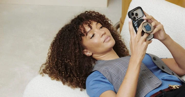 Maison Kitsuné x CASETiFYコラボのグリップスタンド付きスマホケースでくつろぐ女性