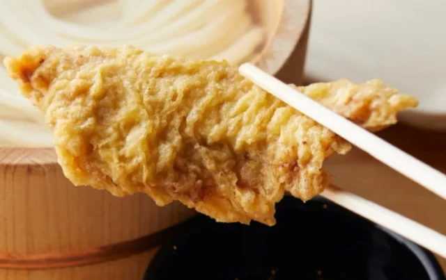 箸で持ち上げられた揚げたてのかしわ天