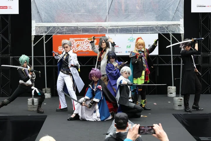 ステージ上で刀を構えるコスプレイヤーたち