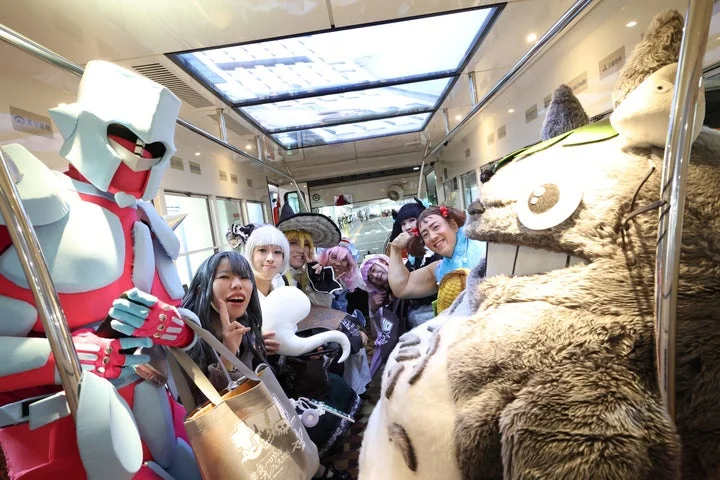 電車内でポーズをとる多様なキャラクターのコスプレイヤーたち
