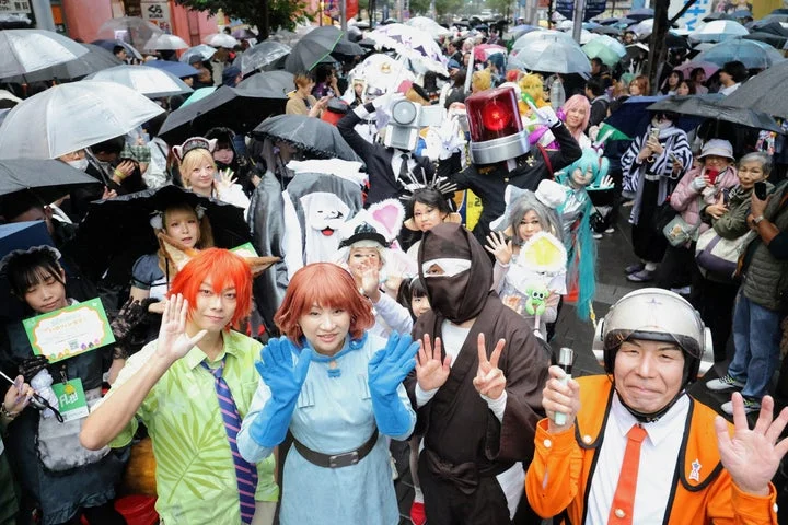 雨にも負けず歓声に応えるパレード参加のコスプレイヤーたち