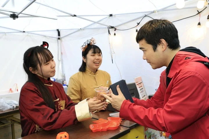 ハロウィンフードフェスでドリンクを受け取る来場者