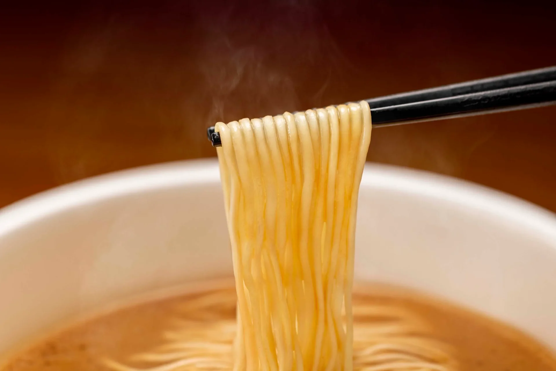 「一蘭とんこつ釜だれ」カップ麺のノンフライ麺を箸で持ち上げた様子